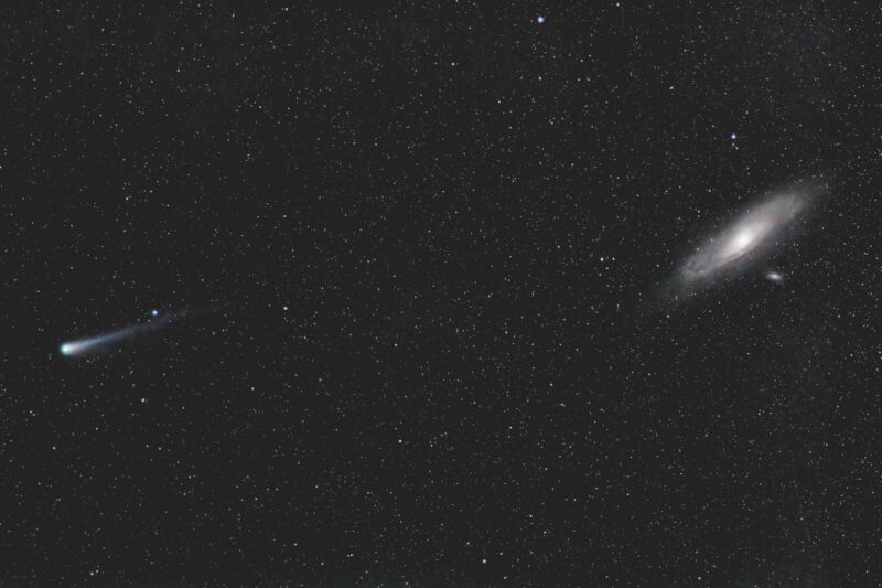 A fuzzy-tailed comet on the left and an oblique spiral galaxy on the right, in a starfield.