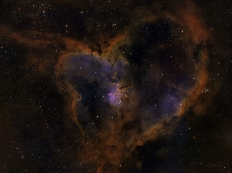 Reddish heart-shaped nebulosity over a background of distant stars.