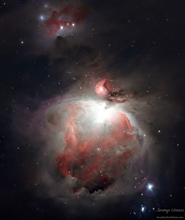 Grandes remolinos de nebulosidad roja brillante sobre un fondo de estrellas distantes.