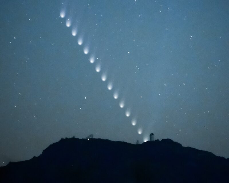 Multiple images of a comet making an angled line toward the hills.