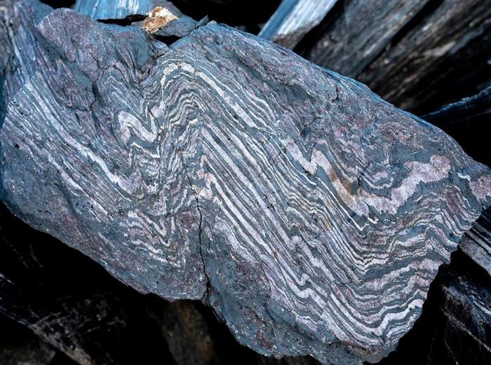 Earth's magnetic field: A rock showing many narrow zigzag gray and white stripes.