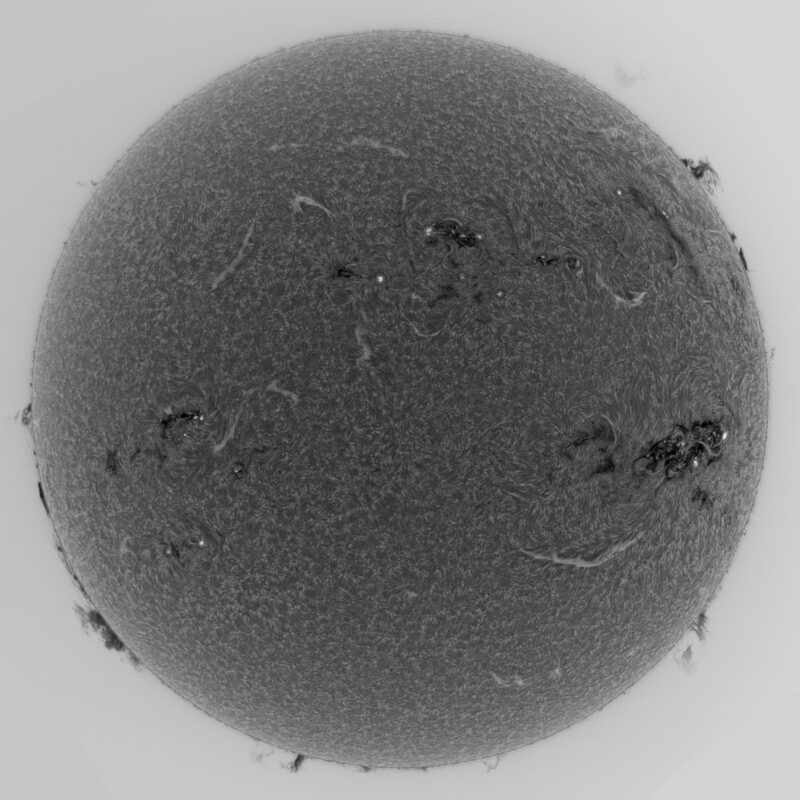 The sun, seen as a large gray sphere with a mottled surface.