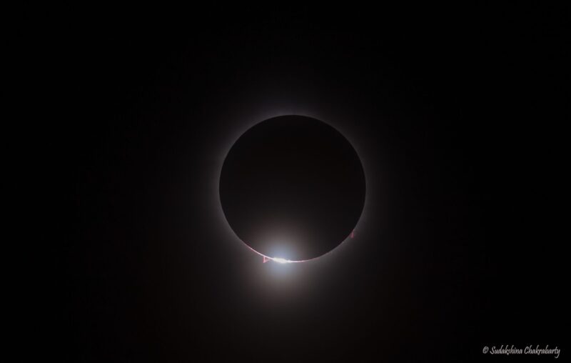 A black circle with a light ring around it and a brighter spot at the bottom.