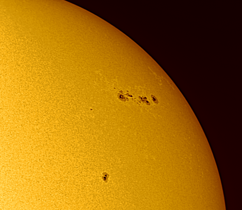 The sun, seen as a sectional yellow sphere with a mottled surface.