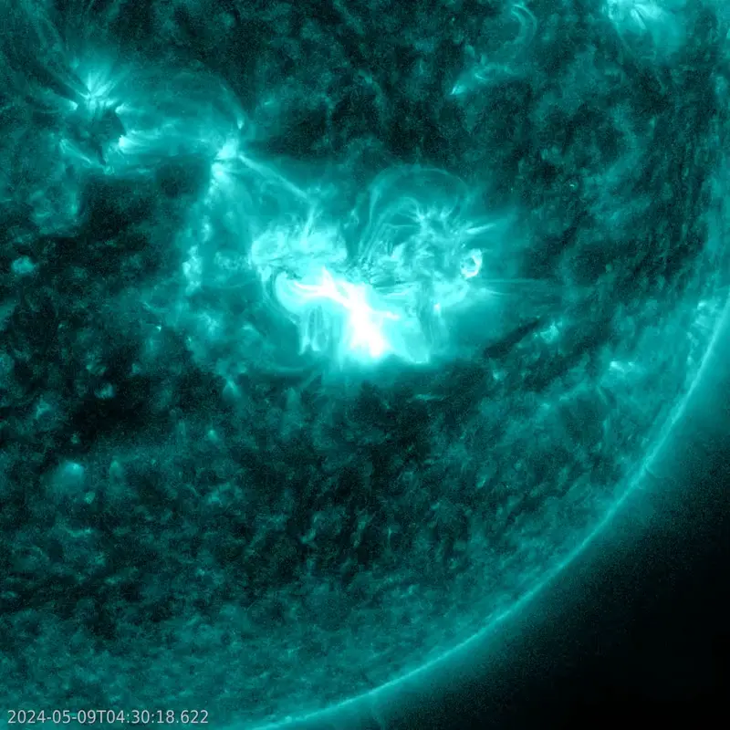 Greenish corner of the sun showing a bright white patch as it erupts.
