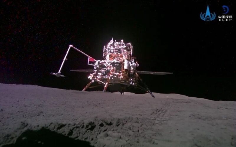 Many-armed mechanical device standing on shadowy gray lunar surface. Chinese moon lander Chang'e 6