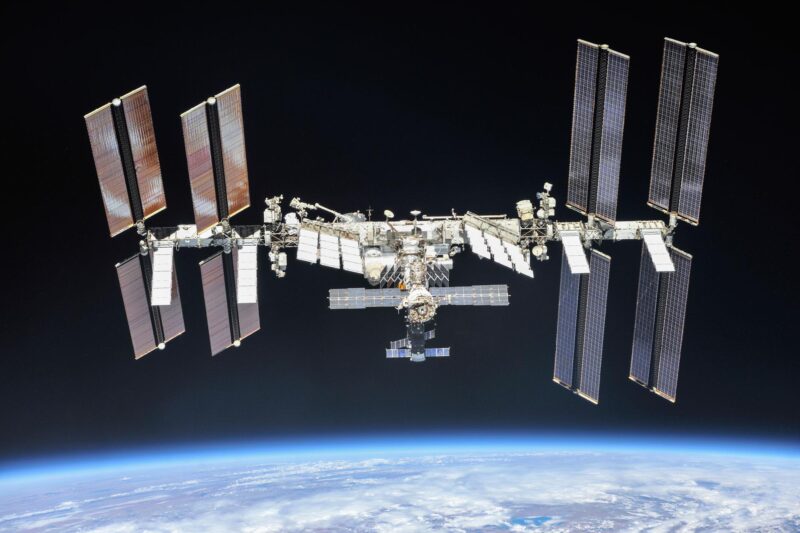 Russian satellite: Space station with large solar panels on either end floating above Earth.