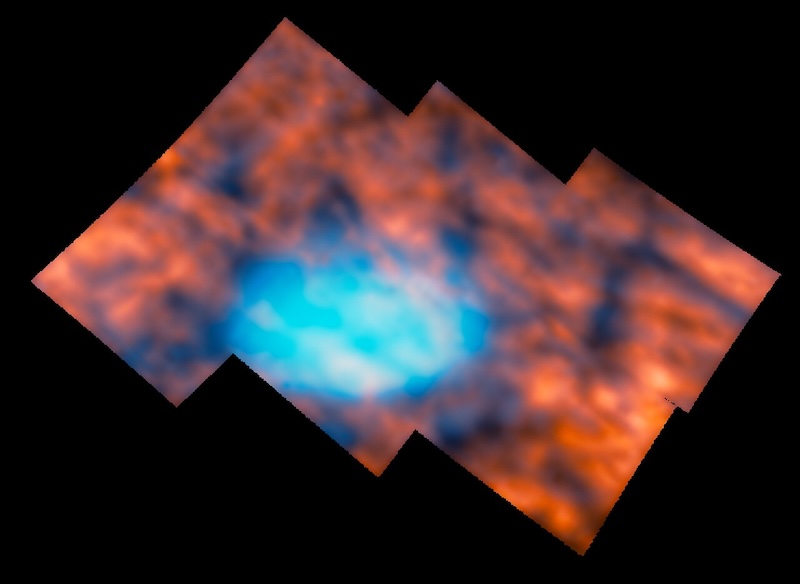 Blurry image of bright whitish oval surrounded by red and dark mottled cloud-like formations.