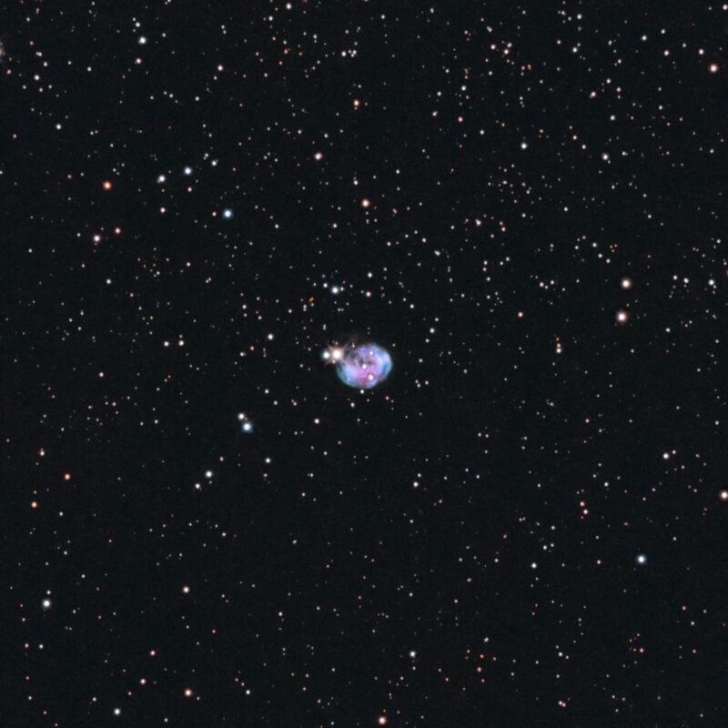 A small spherical cloud with a bluish tint and a background of numerous stars.