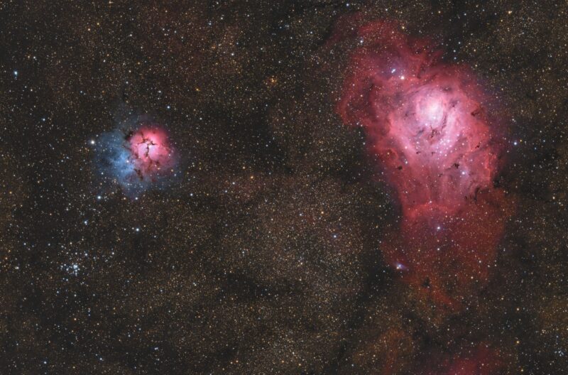 Two nebulous areas with red and blue highlights over a background of numerous faint stars.