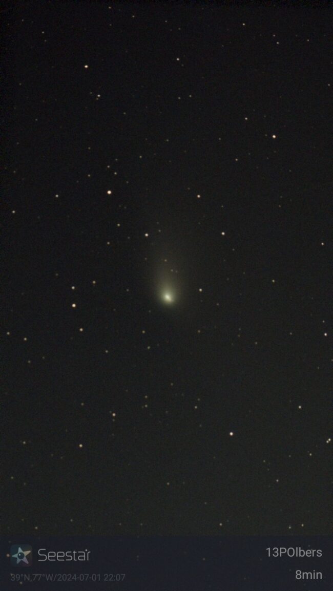 Comet 13P/Olbers: A field of stars showing a brighter, fuzzy object in the center with an upward-pointing tail.