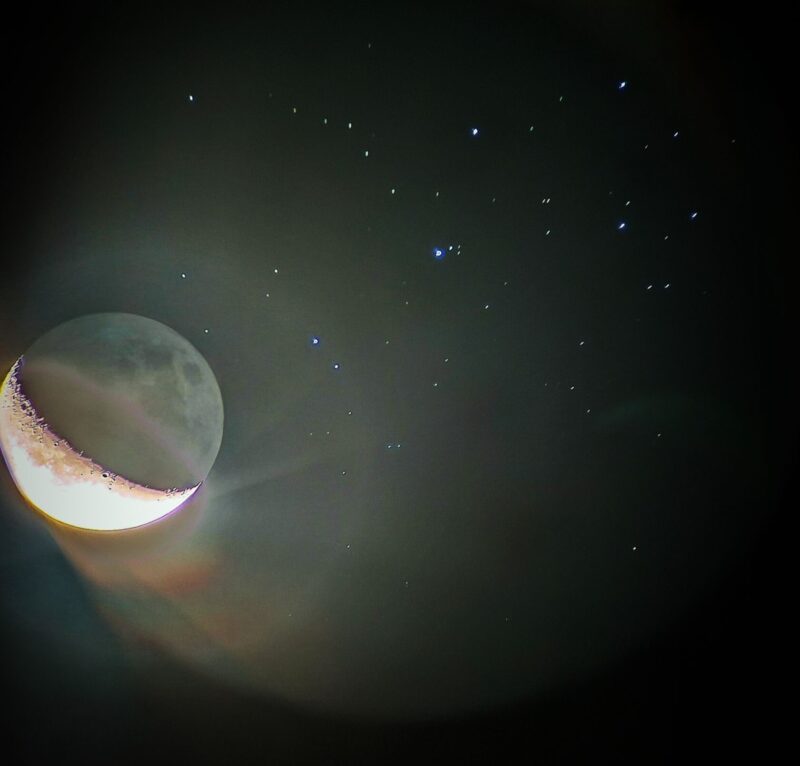 Very bright moon on the left side. There are many white and blue dots to its right side.