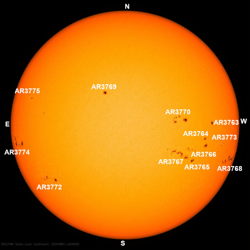 The sun, seen as a large yellow sphere with small dark spots.