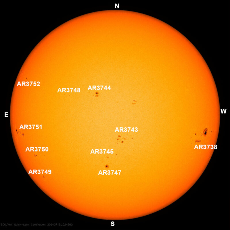 The sun, seen as a large yellow sphere with small dark spots.