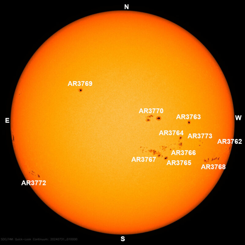 The sun, seen as a large yellow sphere with small dark spots.