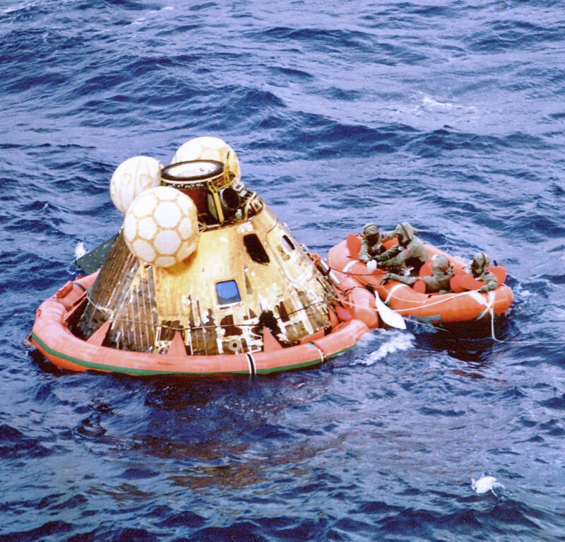 Floating conical module, inflated orange collar at base, yellow inflated balls at top, & orange raft.