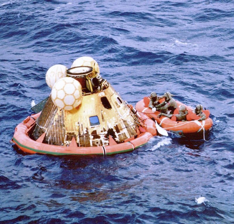 Floating conical module, inflated orange collar at base, yellow inflated balls at top, and orange raft.