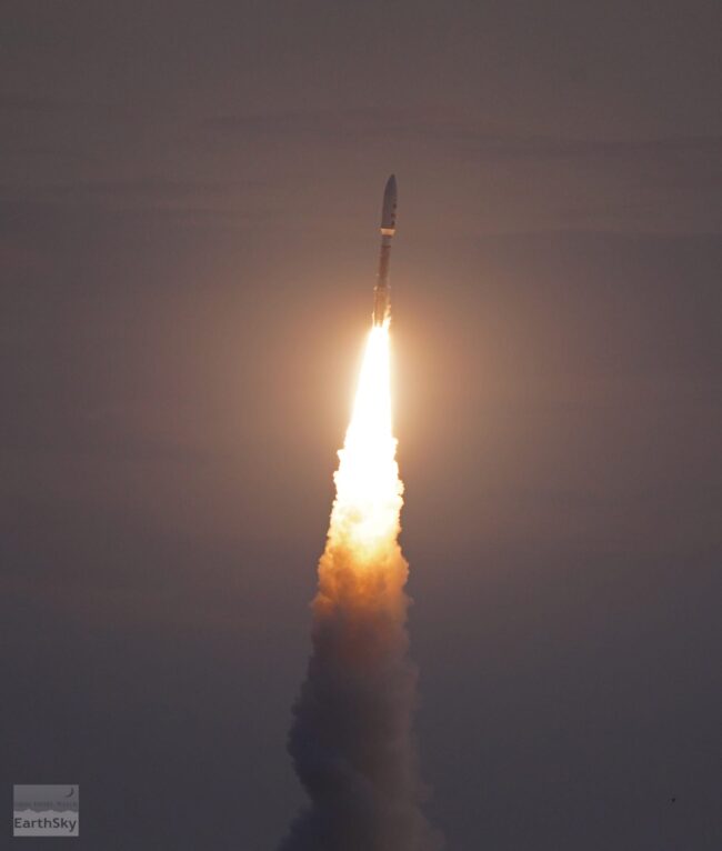 A rocket heading upward with flames and smoke below.