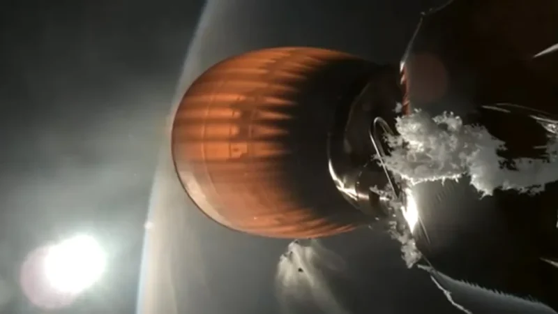 A rusty orange rocket body in space, with the curved of Earth visible.