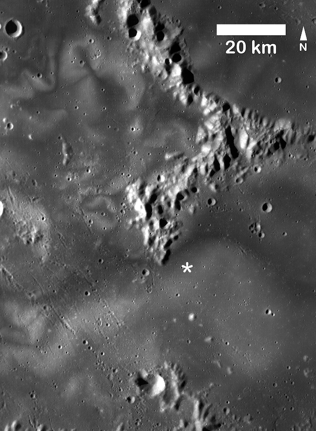 Gray terrain seen from above with mountain ranges, craters and light-colored snaky swirl patterns.