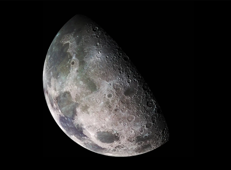 Moon's thin atmosphere: Gray-brown rocky sphere with dark smooth areas and many craters, on black background.