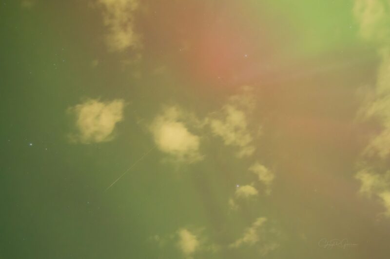 Yellow sky with some pink and green on the right side. There is a thin, faint line in the middle left.