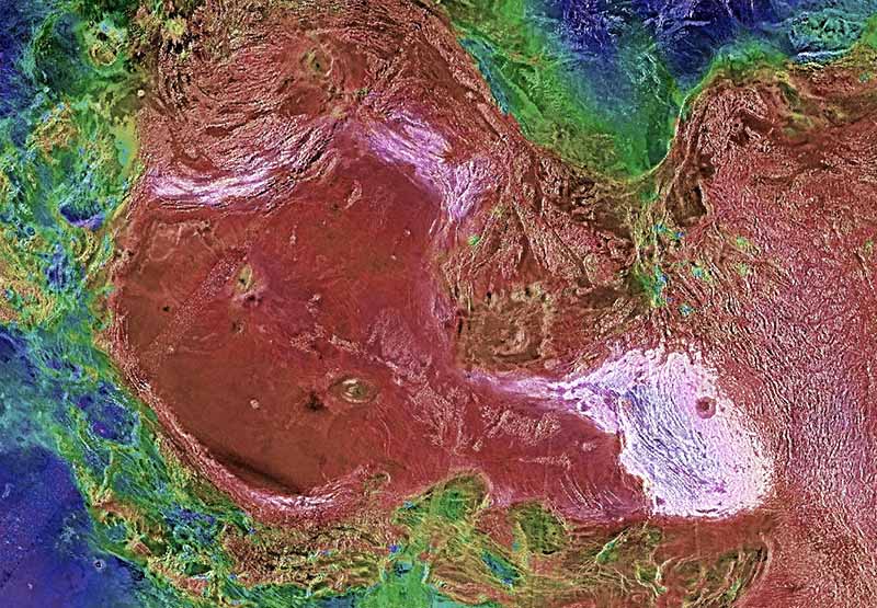 Multicolored terrain with many fine parallel ridges surrounding 2 flat areas, one white and one red.