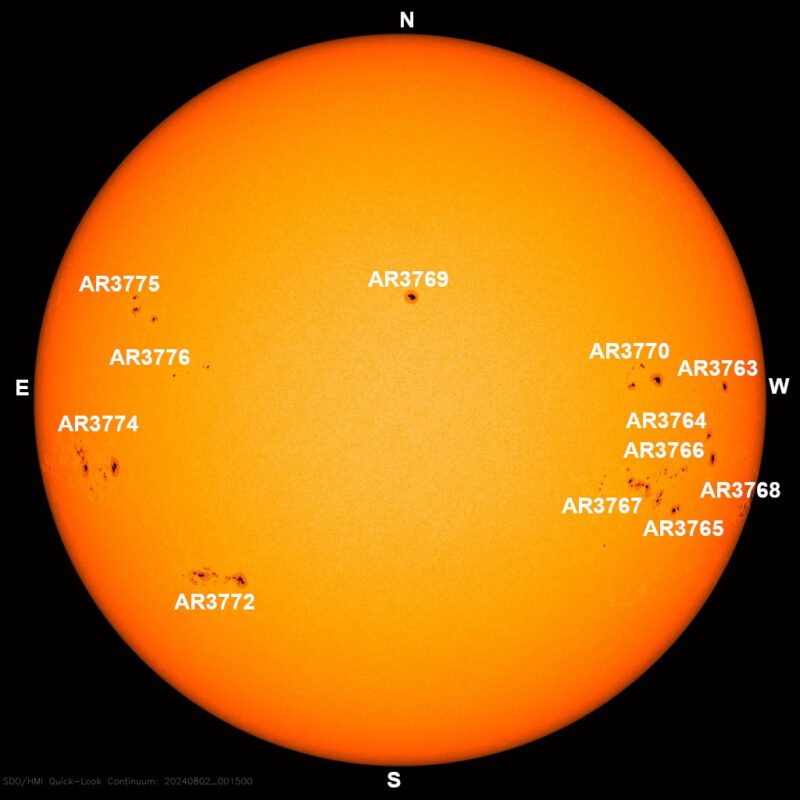 The sun, seen as a large yellow sphere with small dark spots.