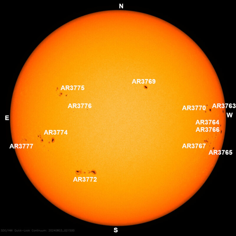 The sun, seen as a large yellow sphere with small dark spots.