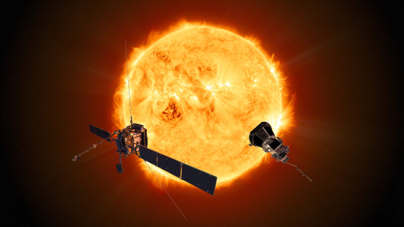 Solar wind: Two angular space probes hang in front of a fiery ball.