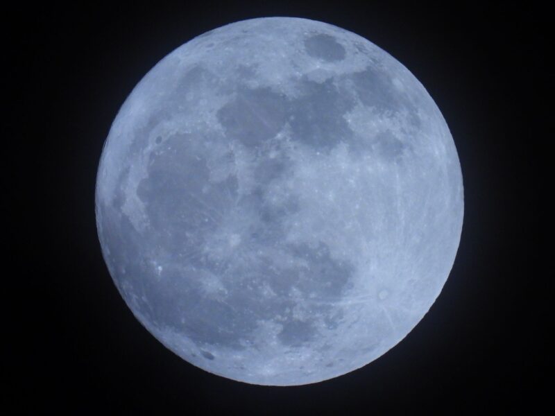 Pale blue moon with some dark areas. The bottom looks like if the sphere fell and broke.