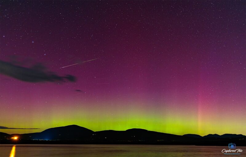 Pink sky with a bright green horizon and a streak crossing the sky.