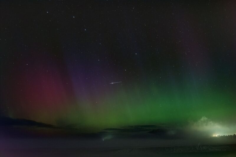 Dark sky with tones of green, purple and pink. A little streak right in the middle.