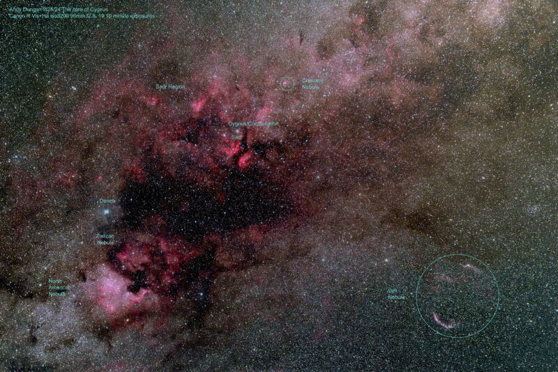 Large reddish patches of nebulosity with dark lanes, in very dense field of foreground stars like dust.