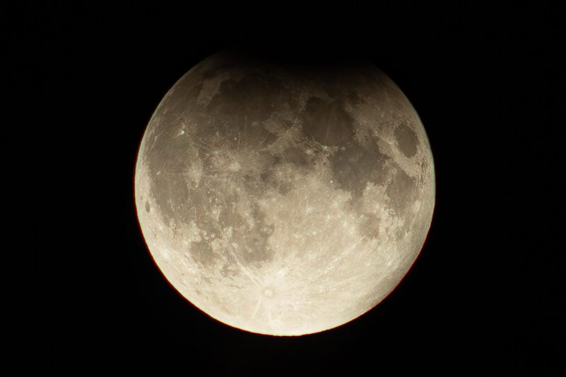 Full moon with a darkened area at top.