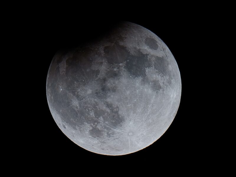 Full moon with darkening at upper left.