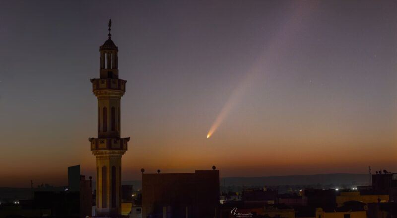 Minaret tower with comet in the sunrise behind.