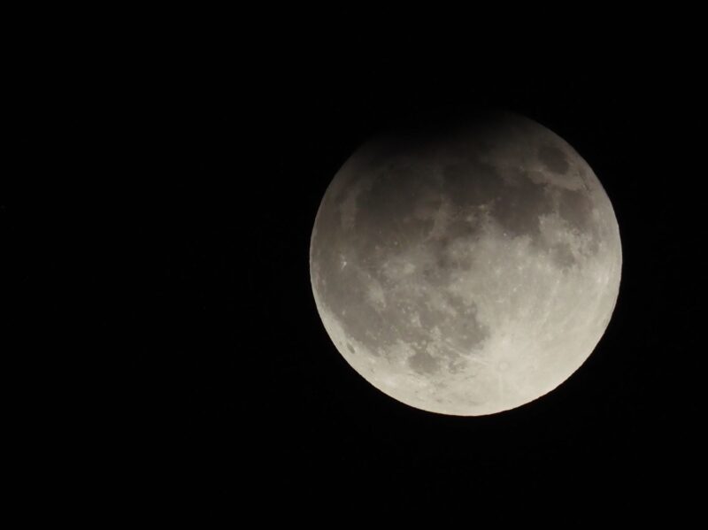 A full moon with a darkening at top.