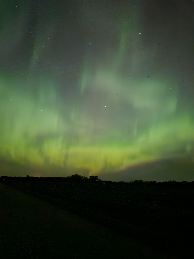 Green aurora over dark horizon. 