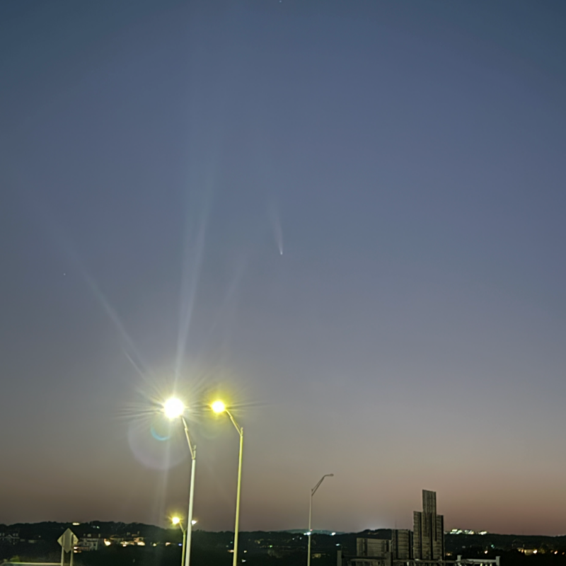 A comet behind bright streetlights.