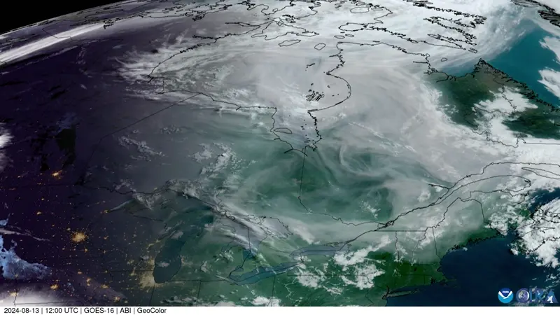 Satellite view of Canada with clouds of white smoke billowing across the outlined provinces.