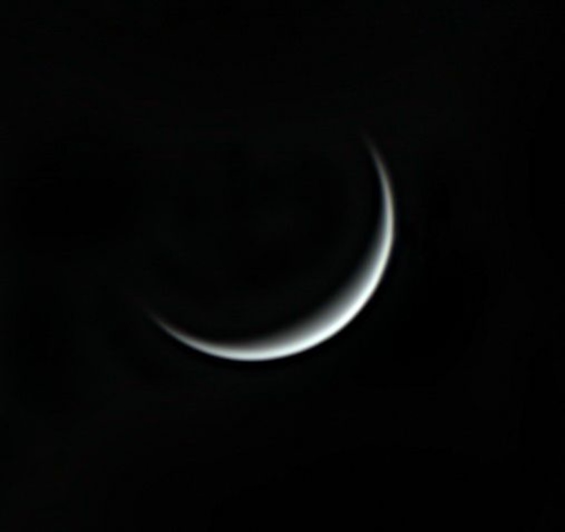 Inferior conjunction: Thin crescent of Venus against a dark sky.