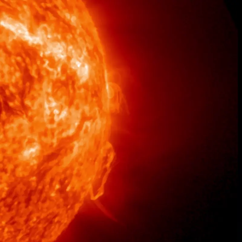 The sun, spurting forth a glowing streamer of gas.