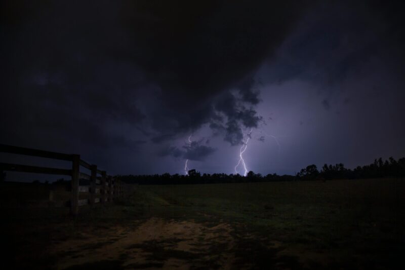 2 lightning strikes in a dark landscape.