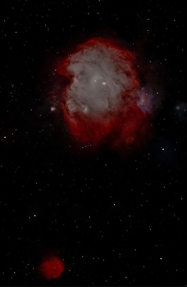 Two nebulous patches, one with large red swirls and dark lanes, and a smaller, reddish, spherical one.