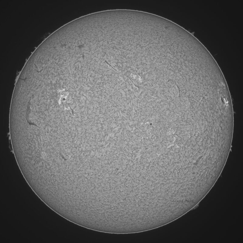 The sun, seen as a large gray sphere with a mottled surface.