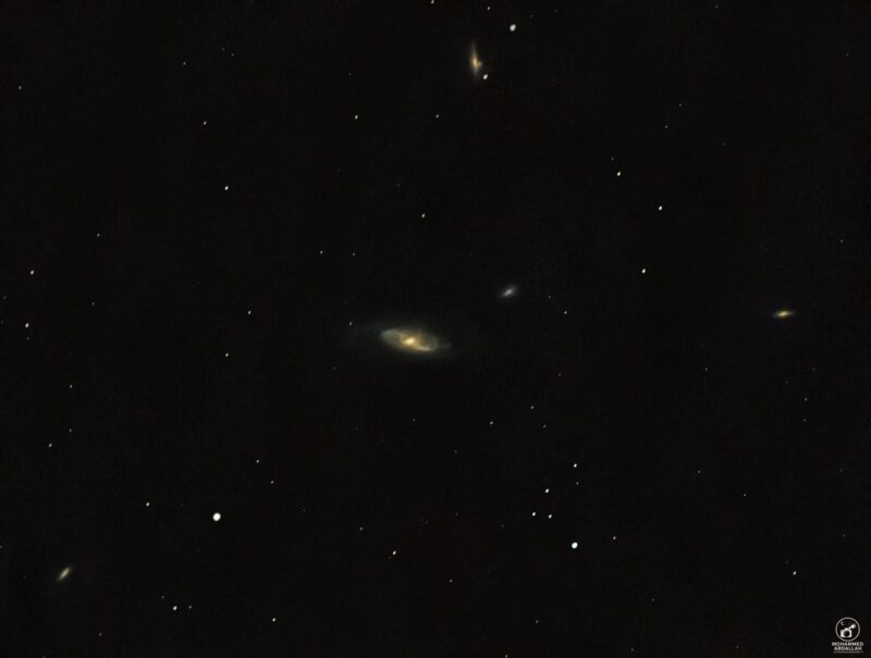 Five small, nebulous, yellowish patches with sparse foreground stars.