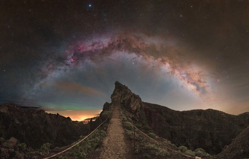 Stairsteps cut into stone heading to a sharp peak with the arch of the Milky Way above it.