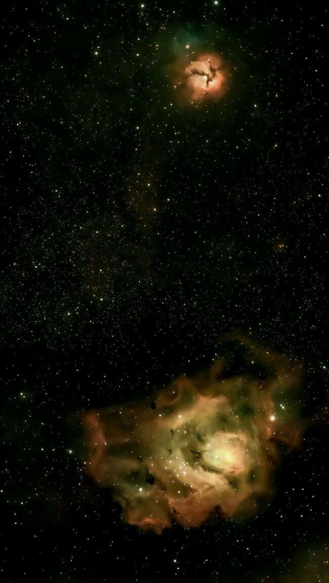 Two nebulous areas with orange and green highlights over a multitude of faint, distant stars.