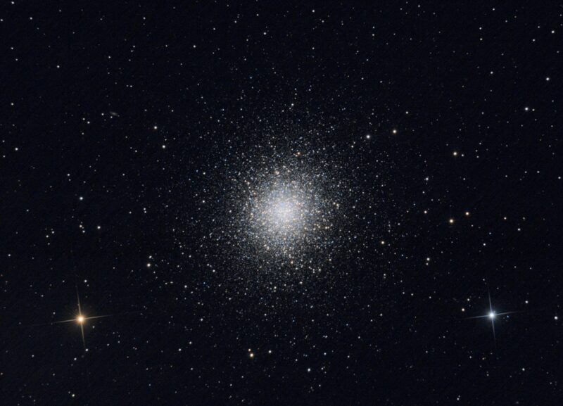 A large, spherical cluster containing thousands of bright yellowish stars.